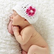 Bebé con gorrito de flor durmiendo