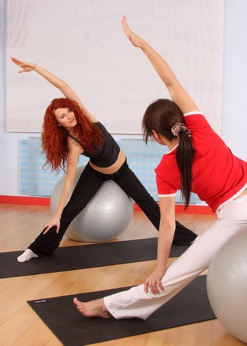 Estiramientos de brazos y abdominales sobre la pelota para la embarazada