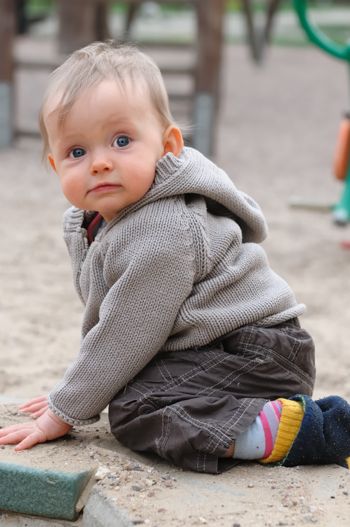 Bebé en la arena del parque infantil