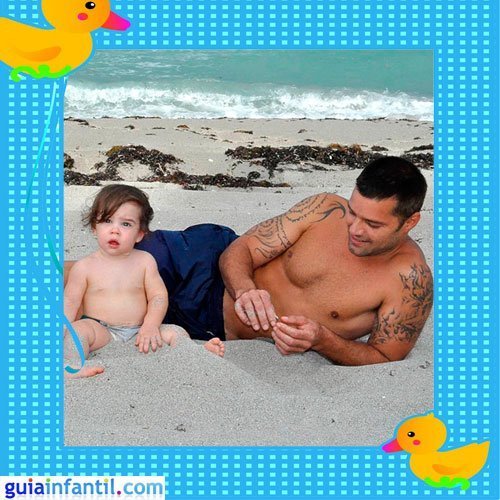 El cantante puertorriqueño con uno de sus hijos gemelos en la playa