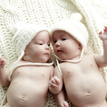Con gorros a juego. Foto tierna de bebé gemelos