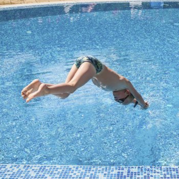 Zambullidas peligrosas de los niños en la piscina