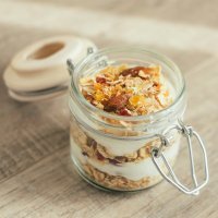 Vasito de queso cremoso con muesli para la merienda de los niños