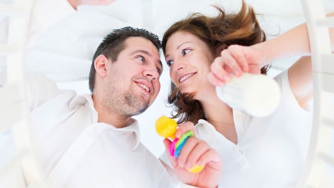 Padre y bebé en la cuna