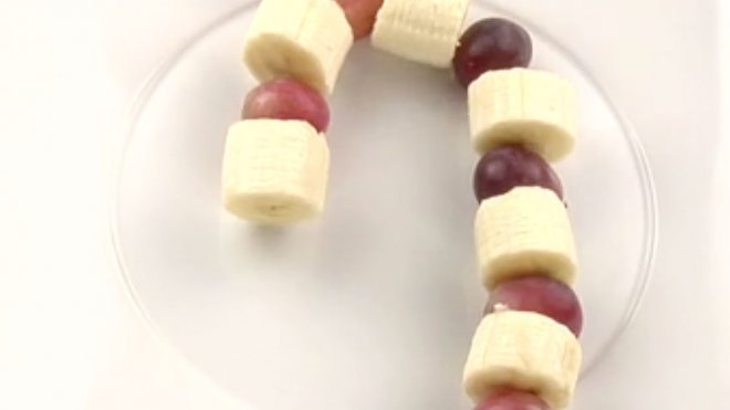 Postre de fruta navideño. Bastón de caramelo para niños