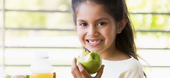 Importancia de la fibra para niños y embarazadas Niña come manzana