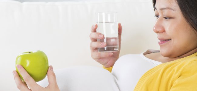 Embarazada mira manzana