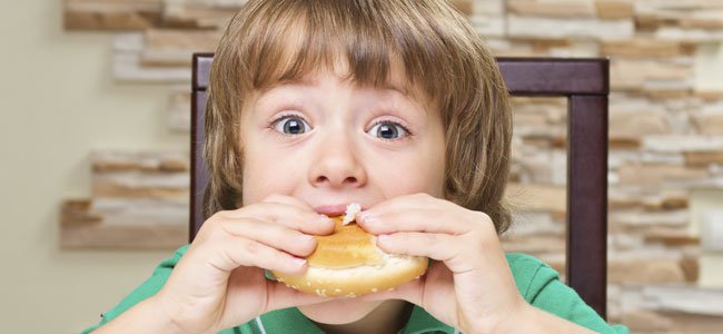 El metabolismo de los niños Niño come hamburguesa