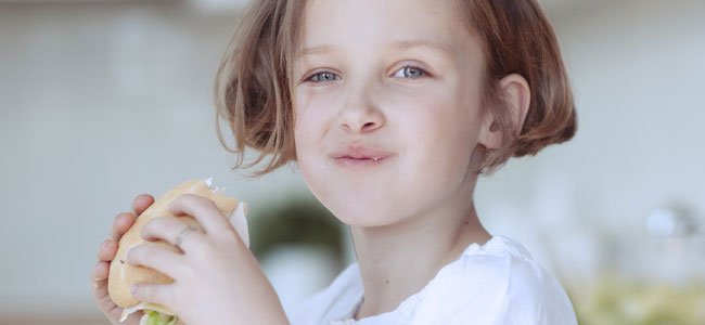 Niña come hamburguesa