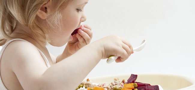 Niña come verduras