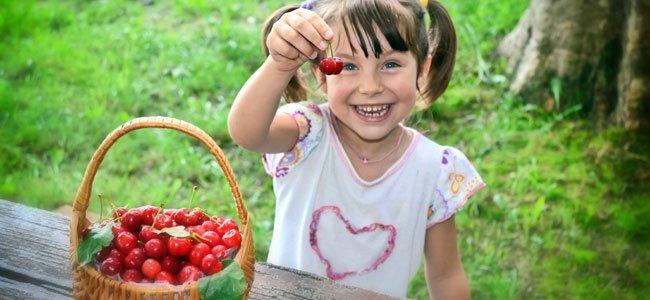 Los beneficios de los alimentos rojos Niña con cerezas