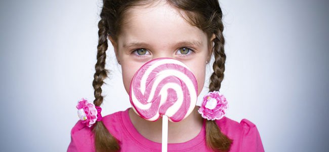 Alimentos que ensucian los dientes de los niños Niña con piruleta