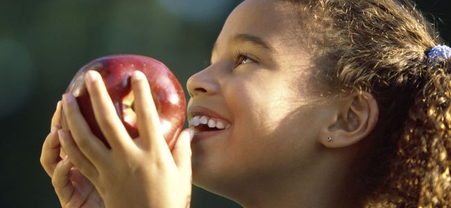 Niña come manzana