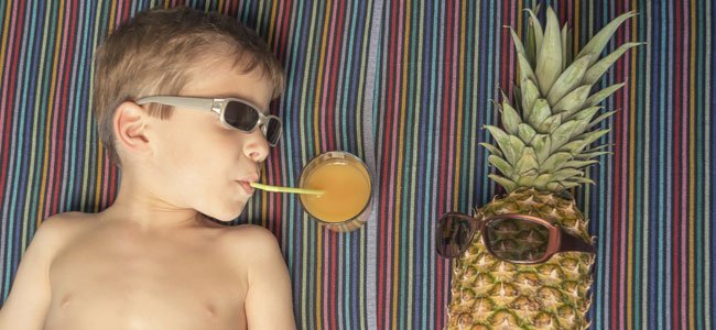 Los zumos de frutas y los niños Niño bebe zumo tumbado