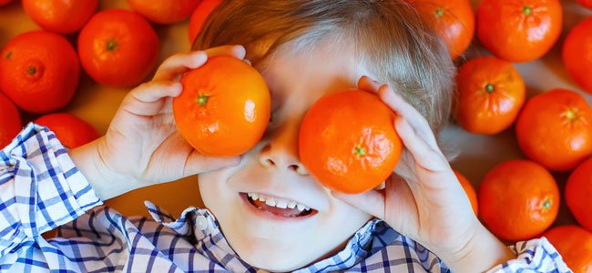 Niño con mandarina