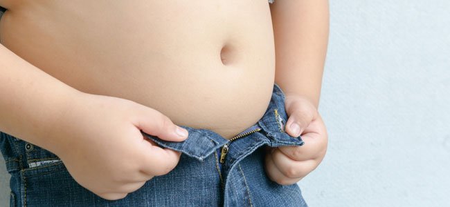 Obesidad infantil Niño se abrocha pantalón