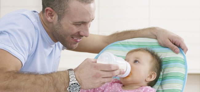 Padre da el biberón al bebé