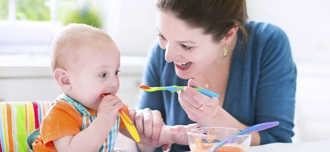 Madre da de comer a bebé