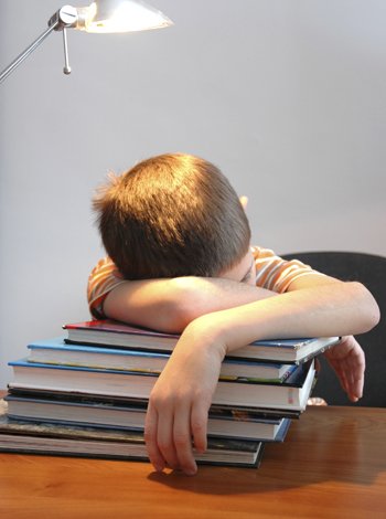 Niño durmiendo encima de los libros