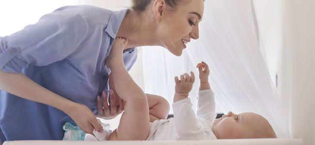 Madre cambia pañal a bebé