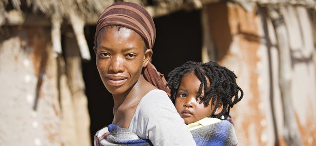 Madre lleva bebé a la espalda