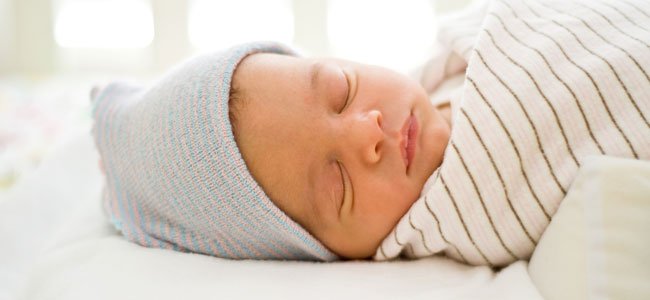 Bebé duerme boca arriba en la cuna