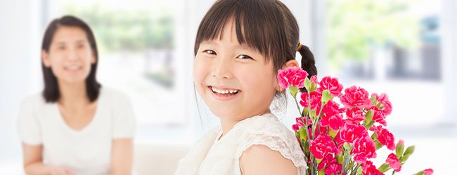 Niña regala flores a su madre