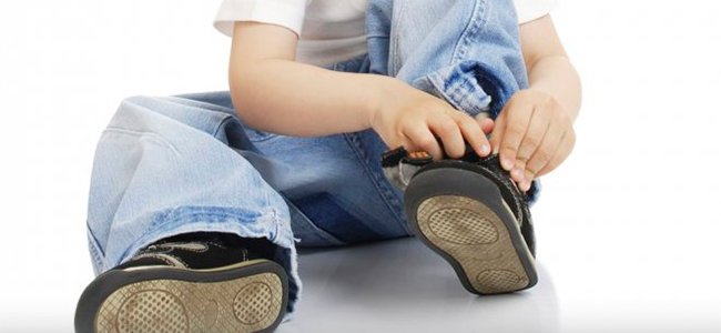 Niño amarra cordón zapatillas, niño autónomo