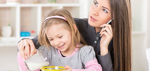 Madre sirve a su hija mientras habla por el movil