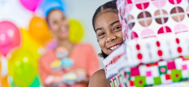 Cómo enseñar a los niños a no ser codiciosos Niña con muchos regalos