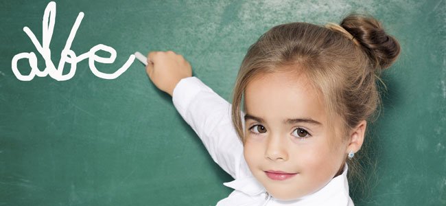 NIña escribe en la pizarra