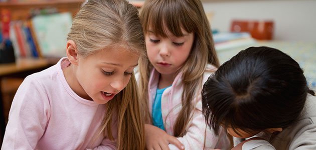 Niños que se dejan influir por otros Niña lee y otros la siguen