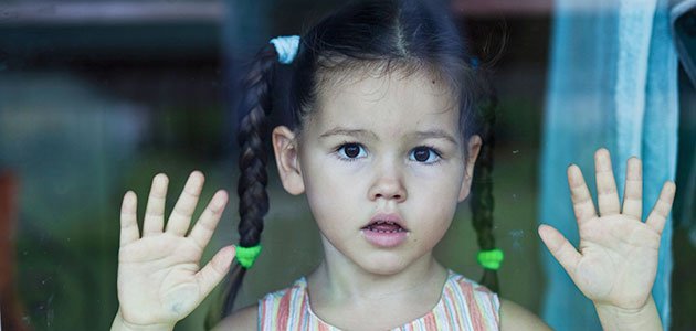 Cómo prevenir el maltrato infantil Niña mira por un cristal