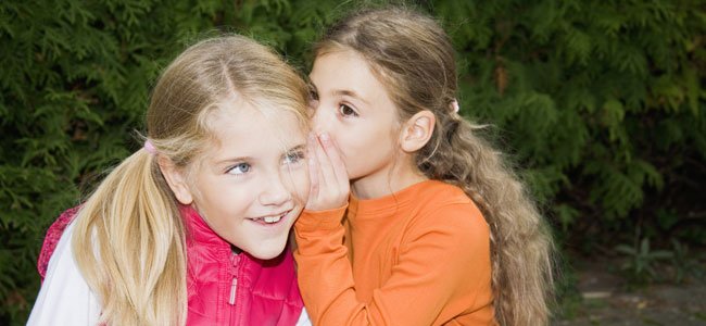 Cómo ayudar a los niños a protegerse de personas tóxicas Niña dice secretos al oído