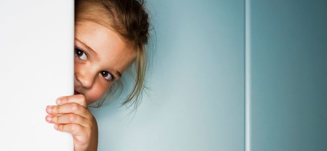 Niña mira por la puerta