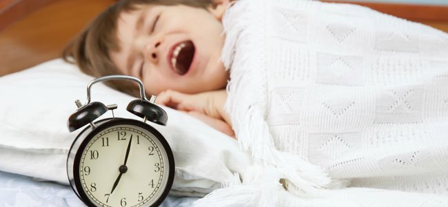 Niño bosteza con reloj