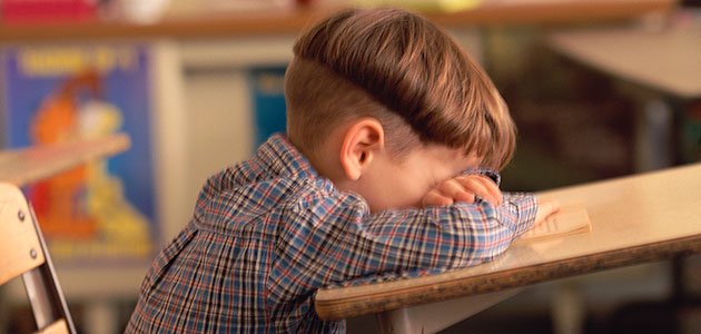 niño llora en pupitre