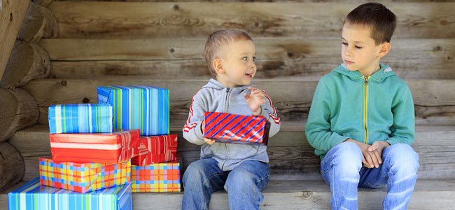 Niño chincha a otro enseñando un regalo