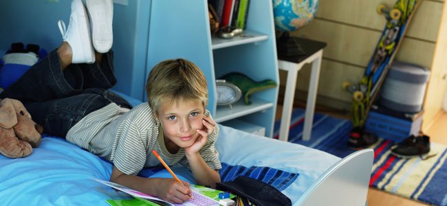 Cuándo se pueden quedar los niños solos en casa NIño hace deberes en su cuarto