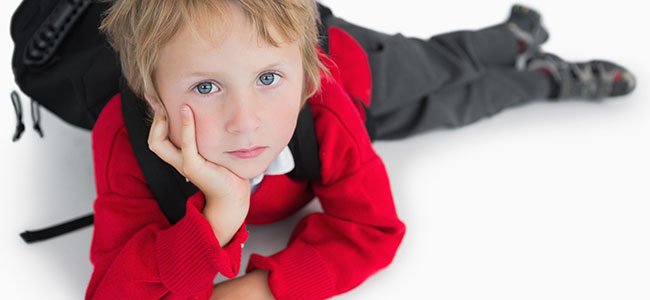 Síndrome postvacacional en los niños Niño bosteza con despertador