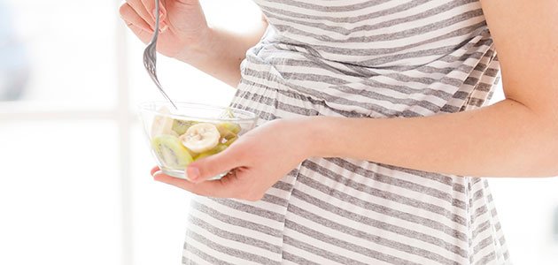 La alimentación en la semana 19 de embarazo Embarazada come kiwi