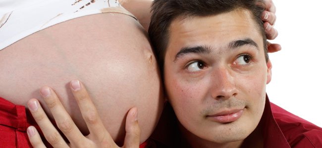 Hombre escucha barriga embarazada