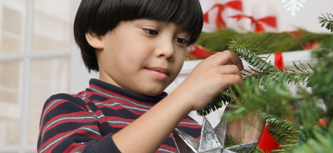 Niño decora árbol