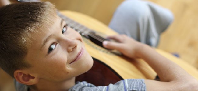Beneficios de la música para los niños Niño toca la guitarra