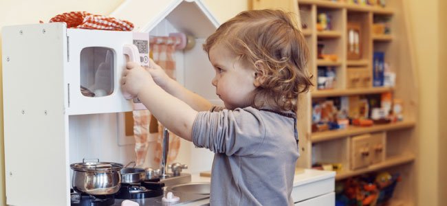 Niña juega con cocinita