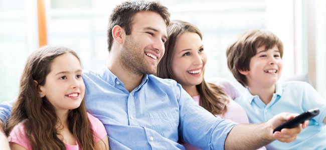 Niños ven la tele con los padres
