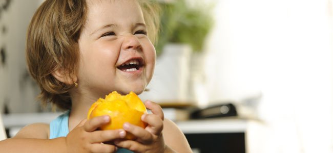 Niña come melocotón