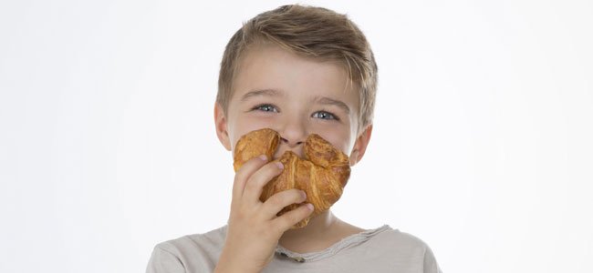 Postres de hojaldre para niños Niño come croissant