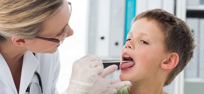 Qué es la gingivoestomatitis en niños y bebés Doctora mira boca niño