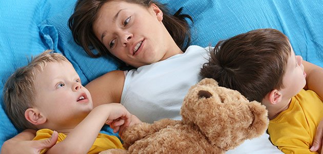Madre con niños en la cama